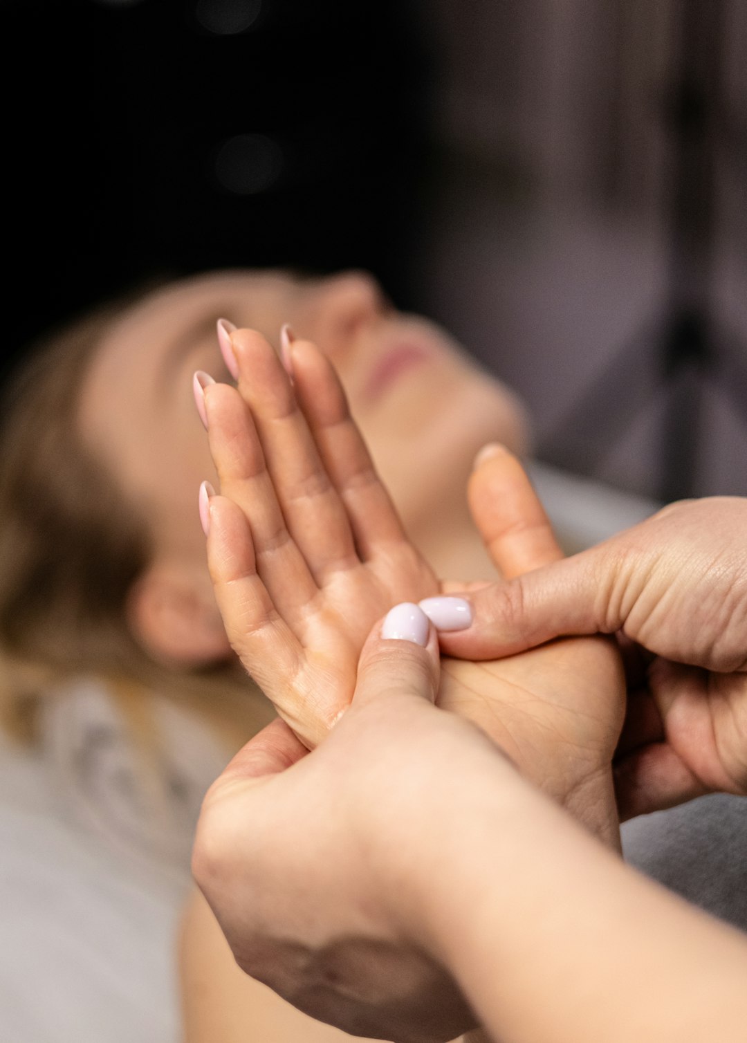 Photo by Anna Keibalo a woman laying on a bed with her hands together